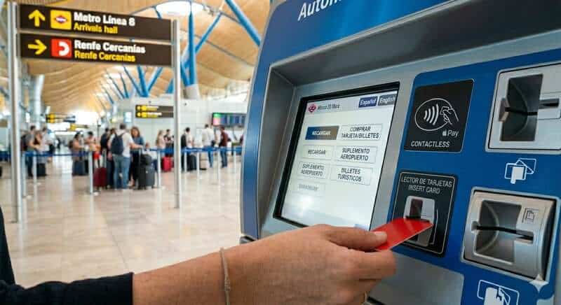 Viajera comprando la Tarjeta Multi de transporte público en una máquina del aeropuerto de Madrid.
